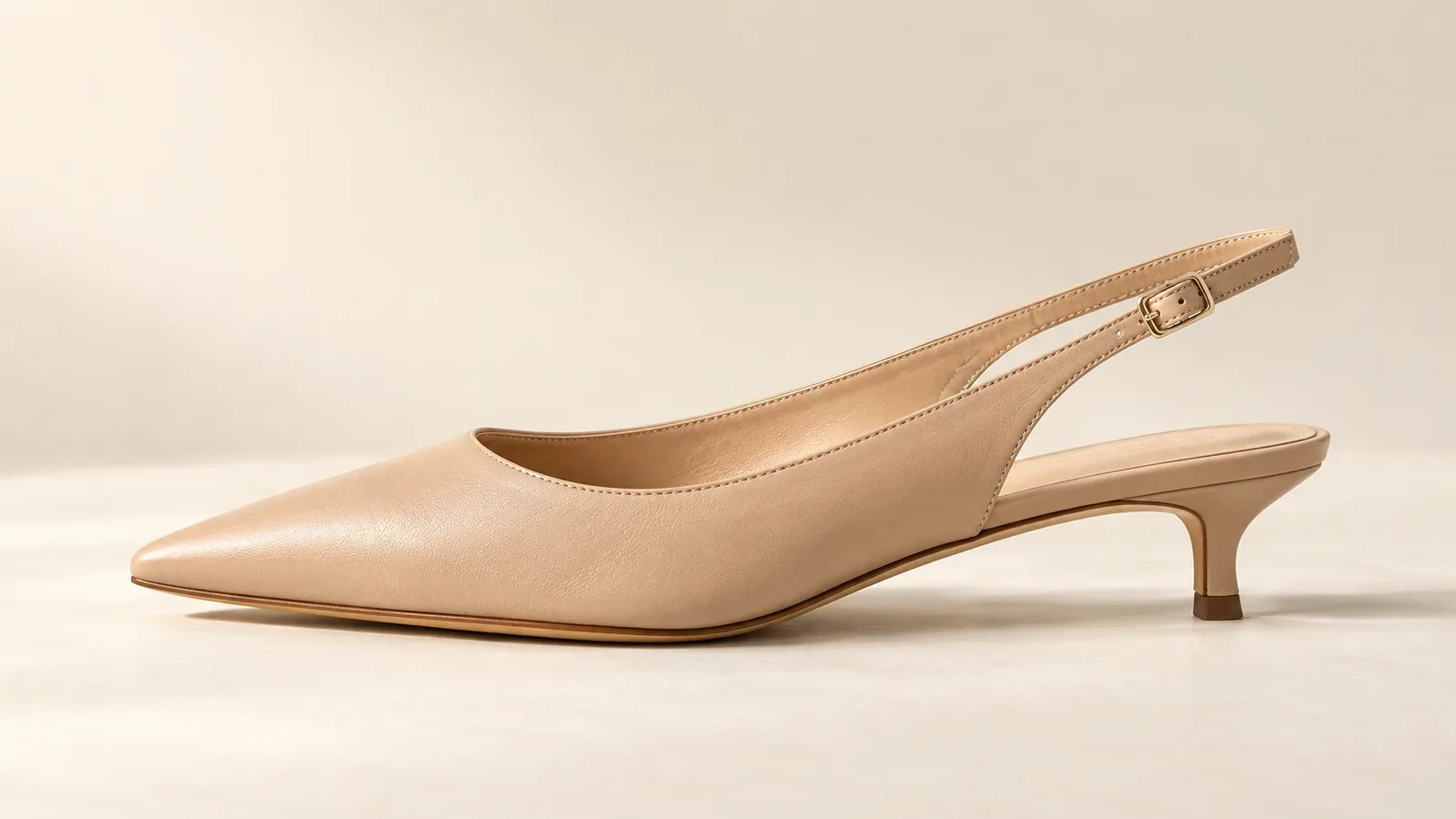 Escarpin slingback beige à bout pointu et petit talon fin, vu de profil sur fond crème.