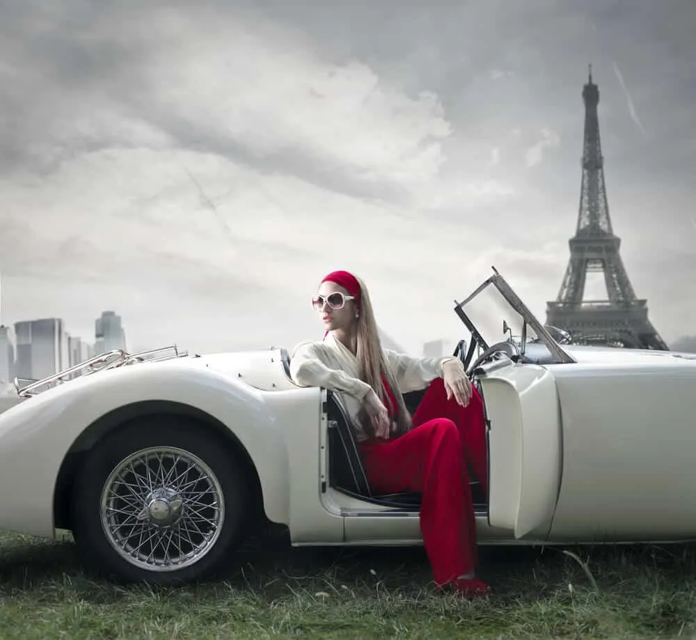 Femme élégante dans une voiture devant la Tour Eiffel.